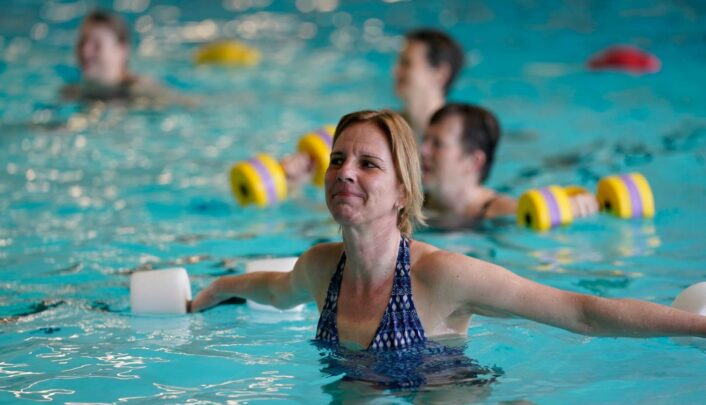 vrouw met dumbbells in water