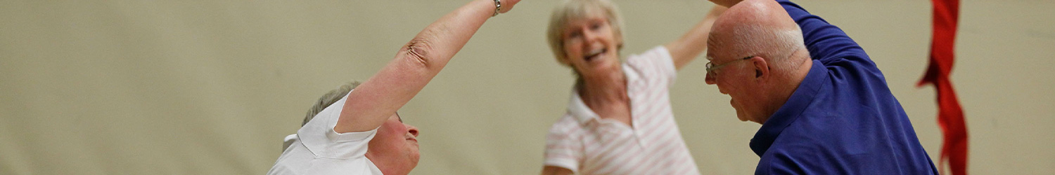 senioren voeren oefeningen uit in een gymzaal