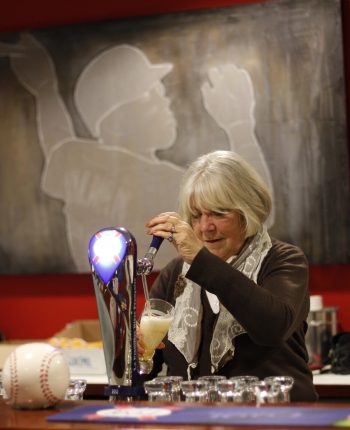 Een mevrouw die een biertje tapt in de kantine