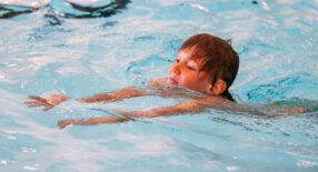 jongetje zwemt schoolslag