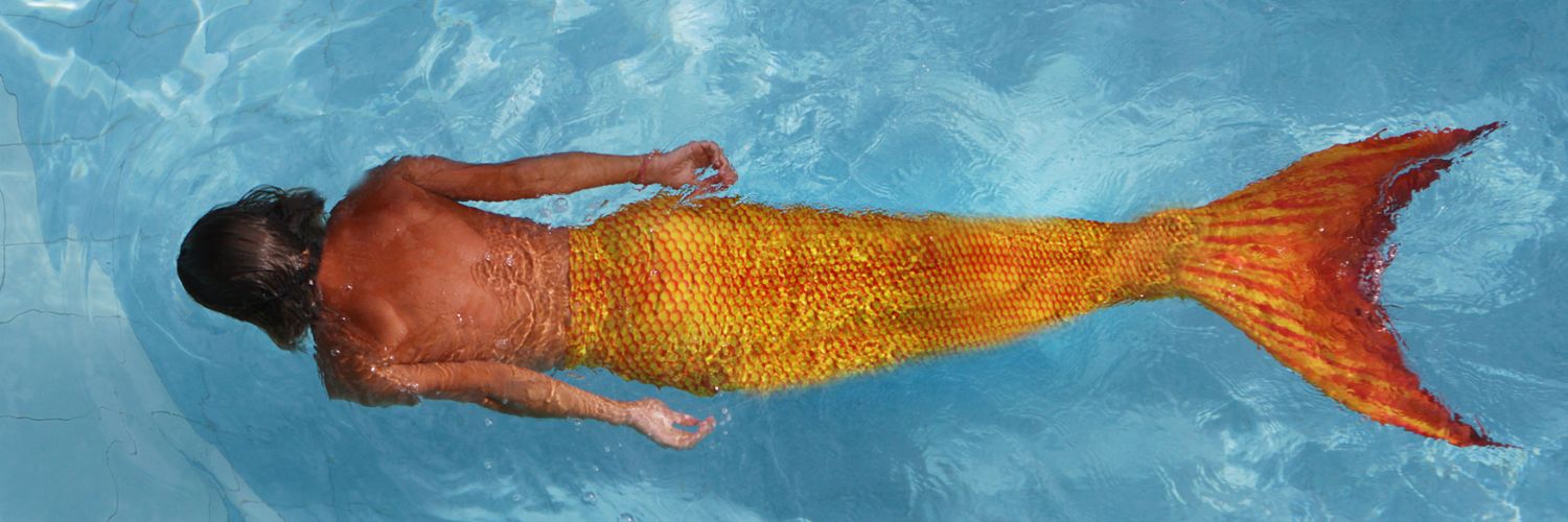 zeemeerman zwemt onder water met een oranje zwemstaart