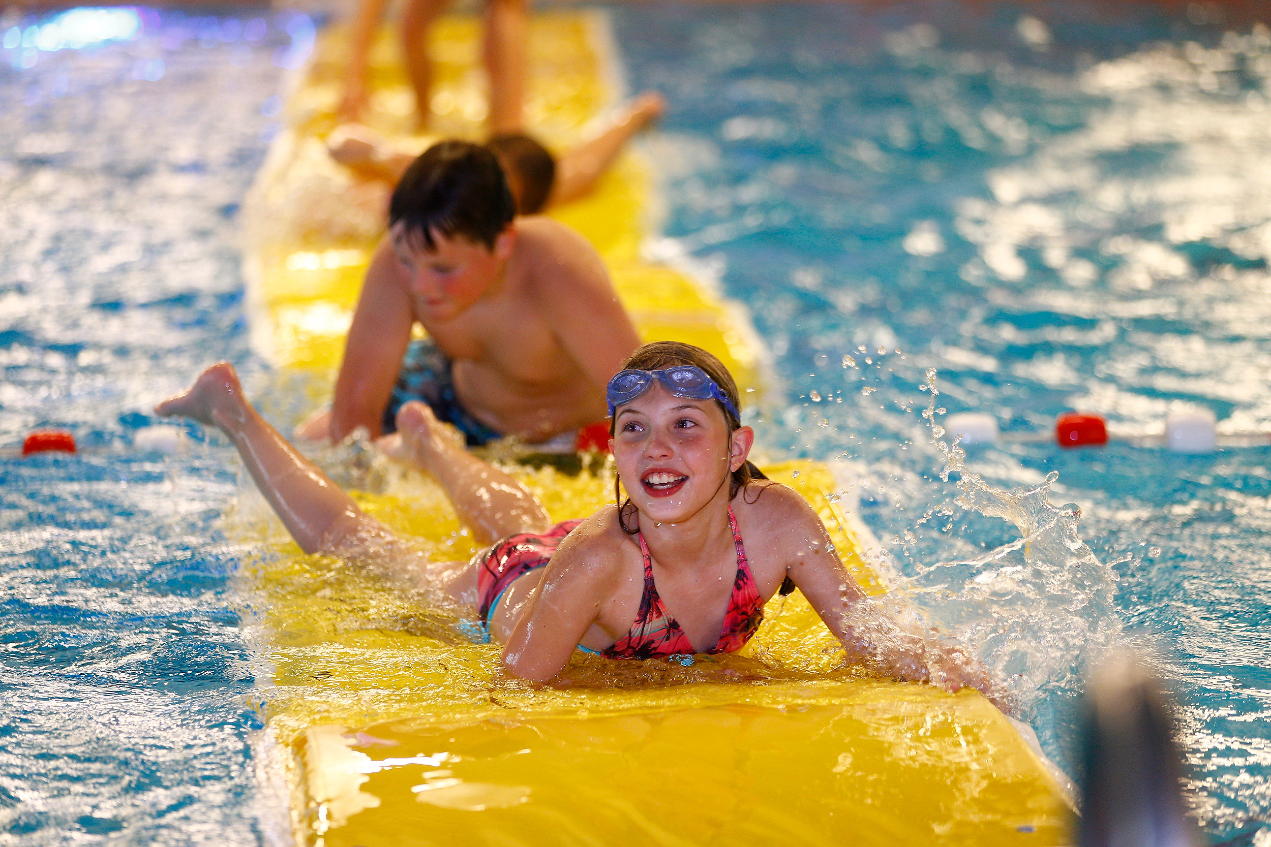 kinderen die op een mat aan het spelen zijn in het water.