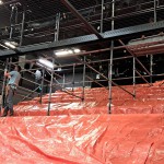 Afdekken trap en plaatsen stijgers in het theater