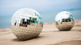 twee discoballen liggen in het zand